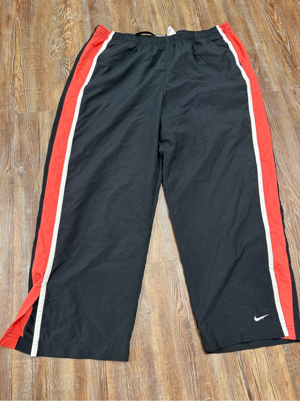 Vintage Y2K Nike black capri track pants with white and orange stripes down the